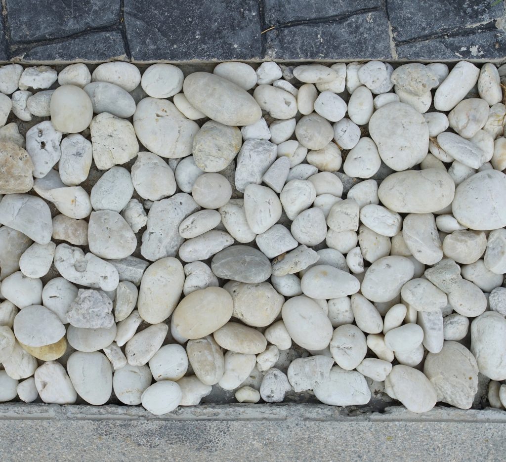 A stone pathway with smooth white rocks arranges along the border.